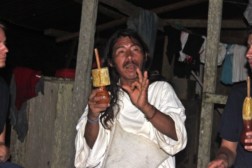 He is explaining that you will see all Kogi carrying a stick like this.  It serves both as their "ID" and to crush shells that are then mixed with coca leaves. 