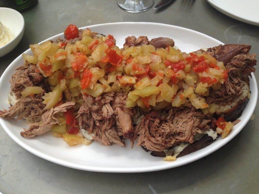 Open face slow cooked lamb sandwich with grilled sourdough, aged provolone and green tomato relish at Iron Gate.