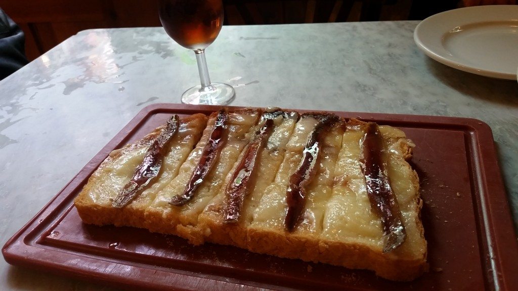 Country bread with cheese and anchovies.  With a side of sherry.