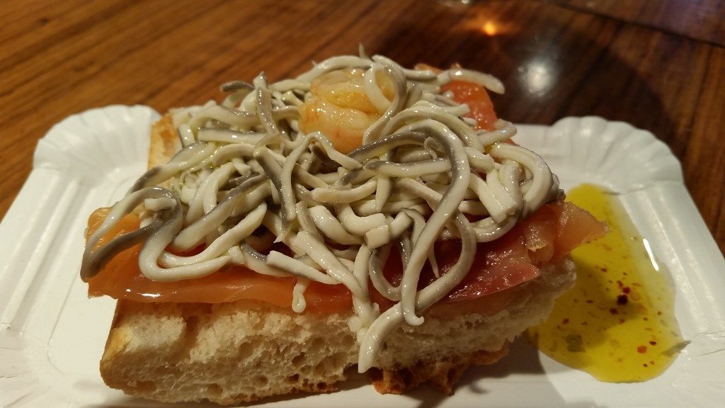 Angulas (baby eels) on toastada with smoked salmon, shrimp and chili olive oil