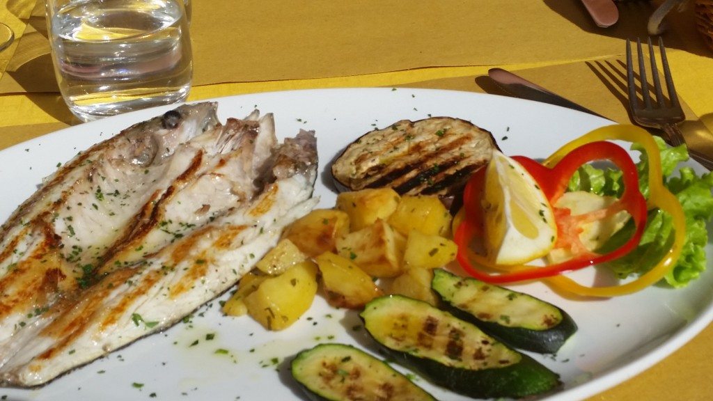 Grilled fish and veggies in a sunny square in Venice.