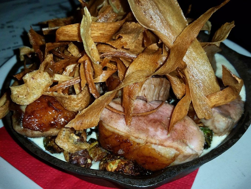 Smoked duck breast with brown butter hollandaise, brussels sprouts and walnuts, topped with parsnip chips.